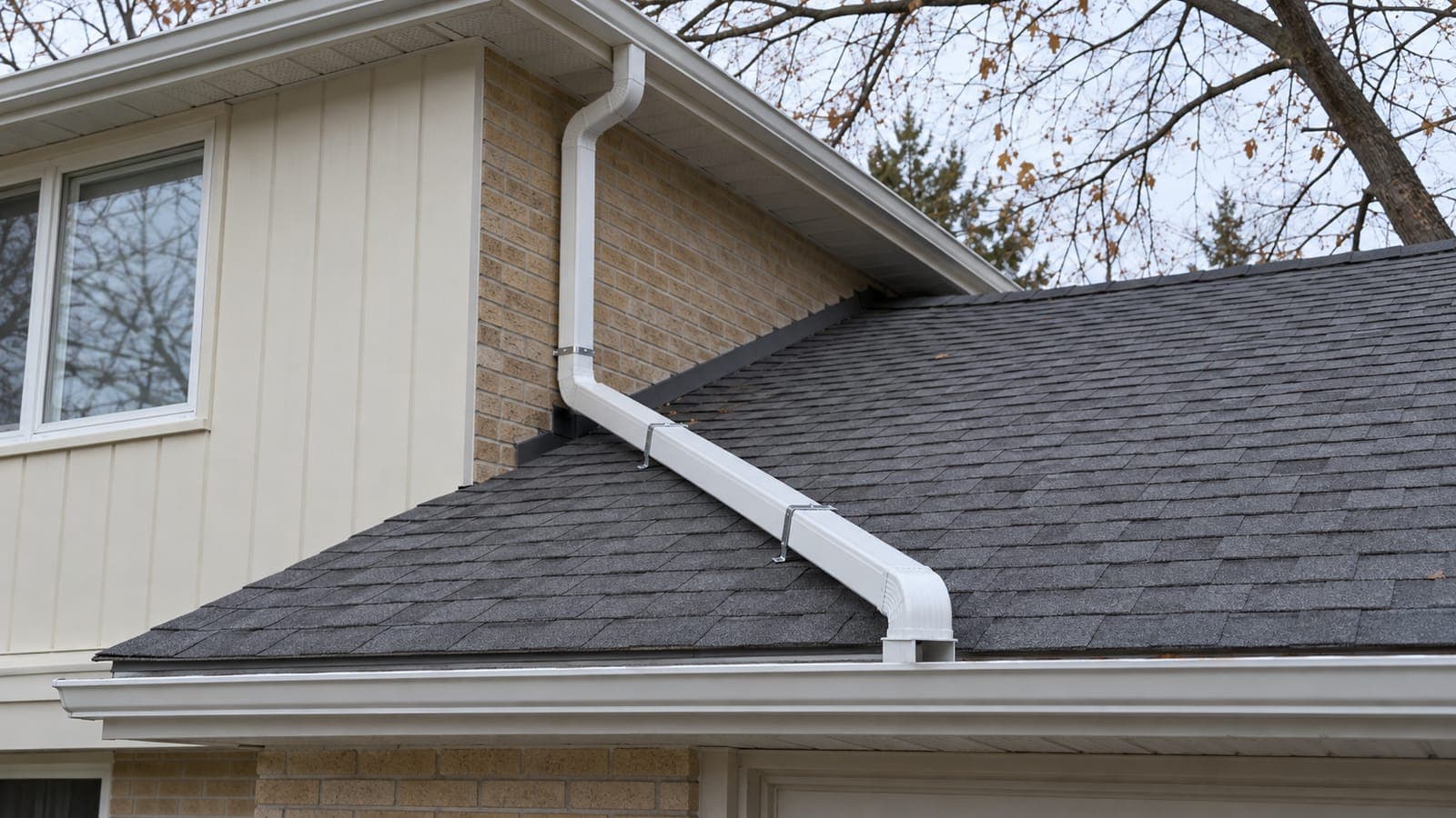 Upper downspout extended down a lower roof and turned into the lower eavestrough with an elbow